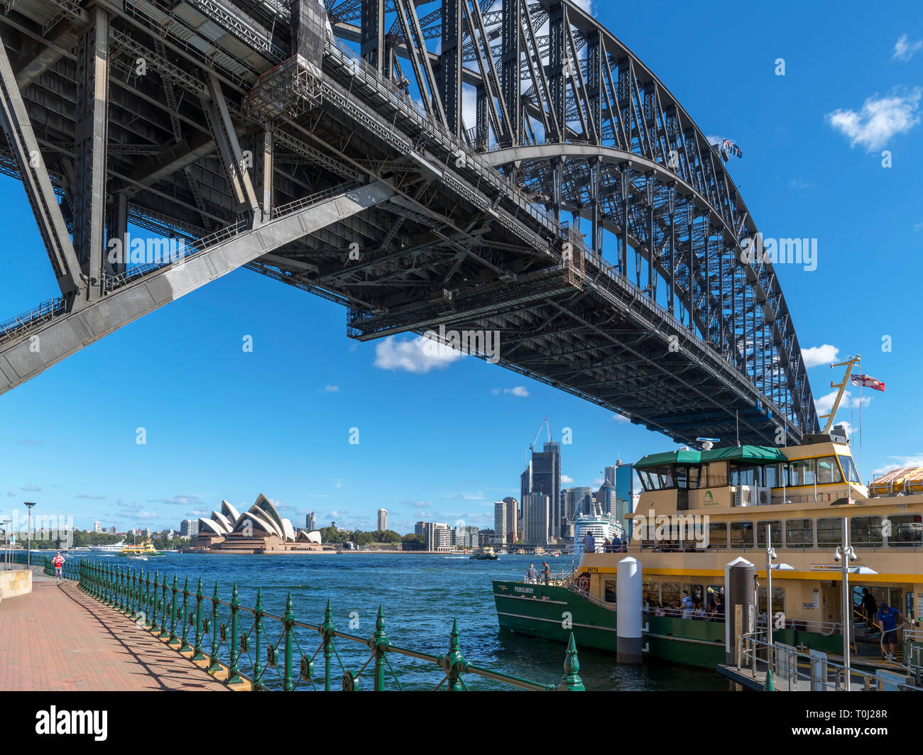 Ferry di Sydney e il Sydney Harbour Bridge in Milsons Point guardando verso la Opera House di Sydney e il Quartiere Affaristico Centrale di Sydney, Australia Foto Stock