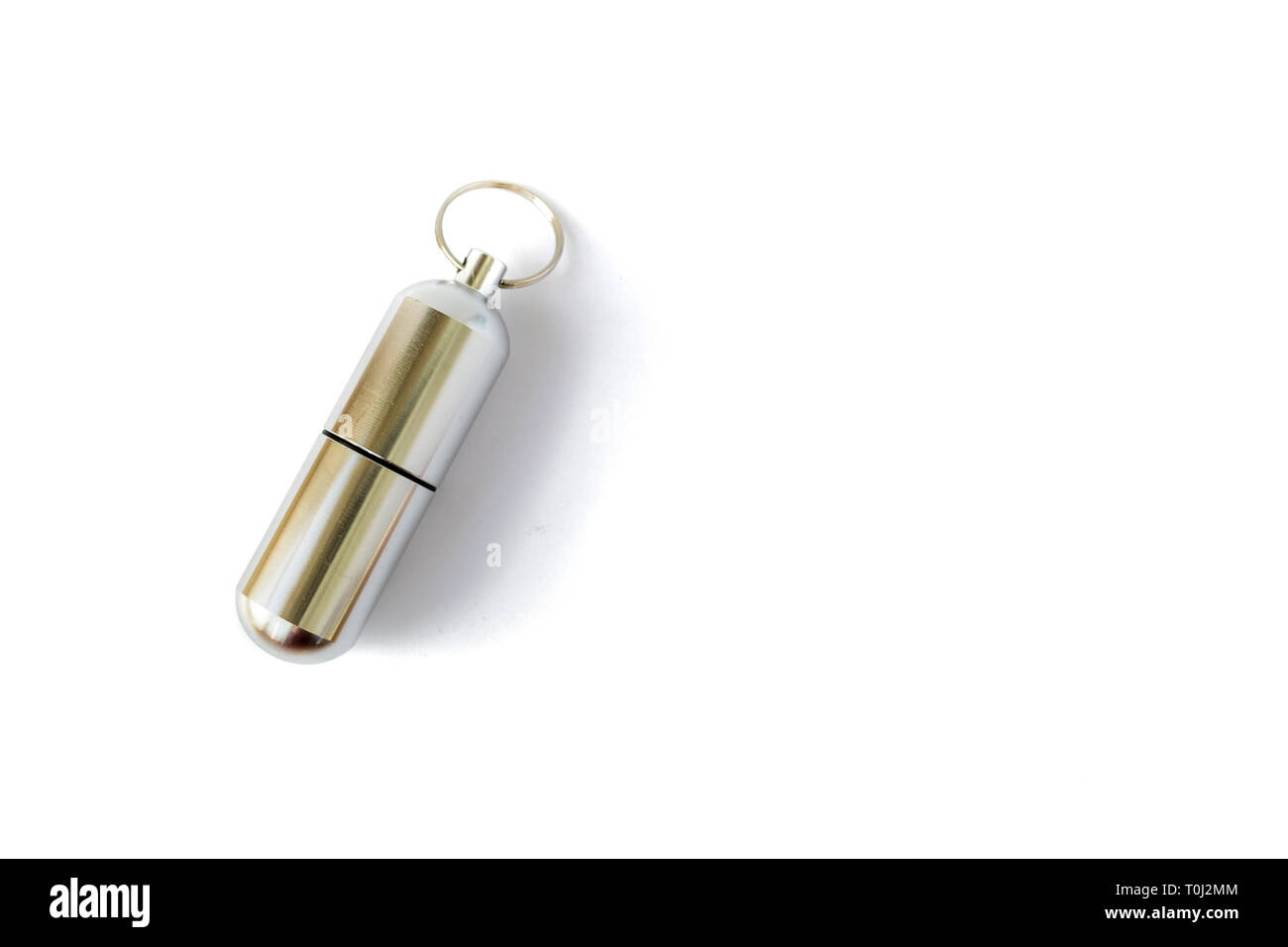 Chiuso pillola di alluminio bottiglia con una chiave ad anello, isolati su sfondo bianco. Chiave catena bottiglia per la memorizzazione di medicina e altri oggetti di piccole dimensioni durante le escursioni o Foto Stock