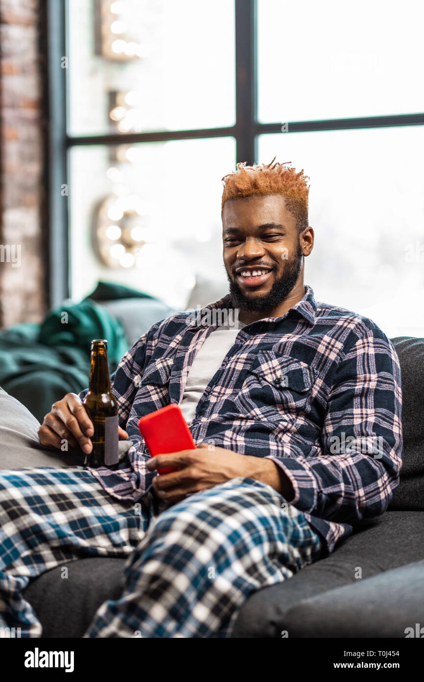 Felice allegro uomo appoggiato sul divano Foto Stock