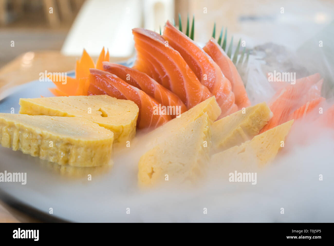 In Giappone il salmone crudo sashimi, dolce uovo e granchio imitazione stick su ghiaccio pod in cucina giapponese del ristorante. Fresco il cibo giapponese concetto. Foto Stock