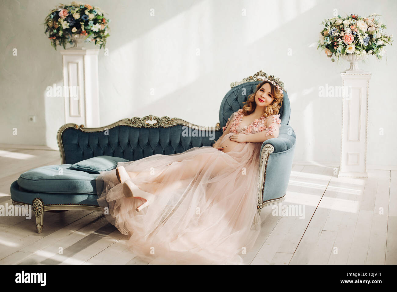 Elegante futura madre in posa lungo abito in polvere. Foto Stock