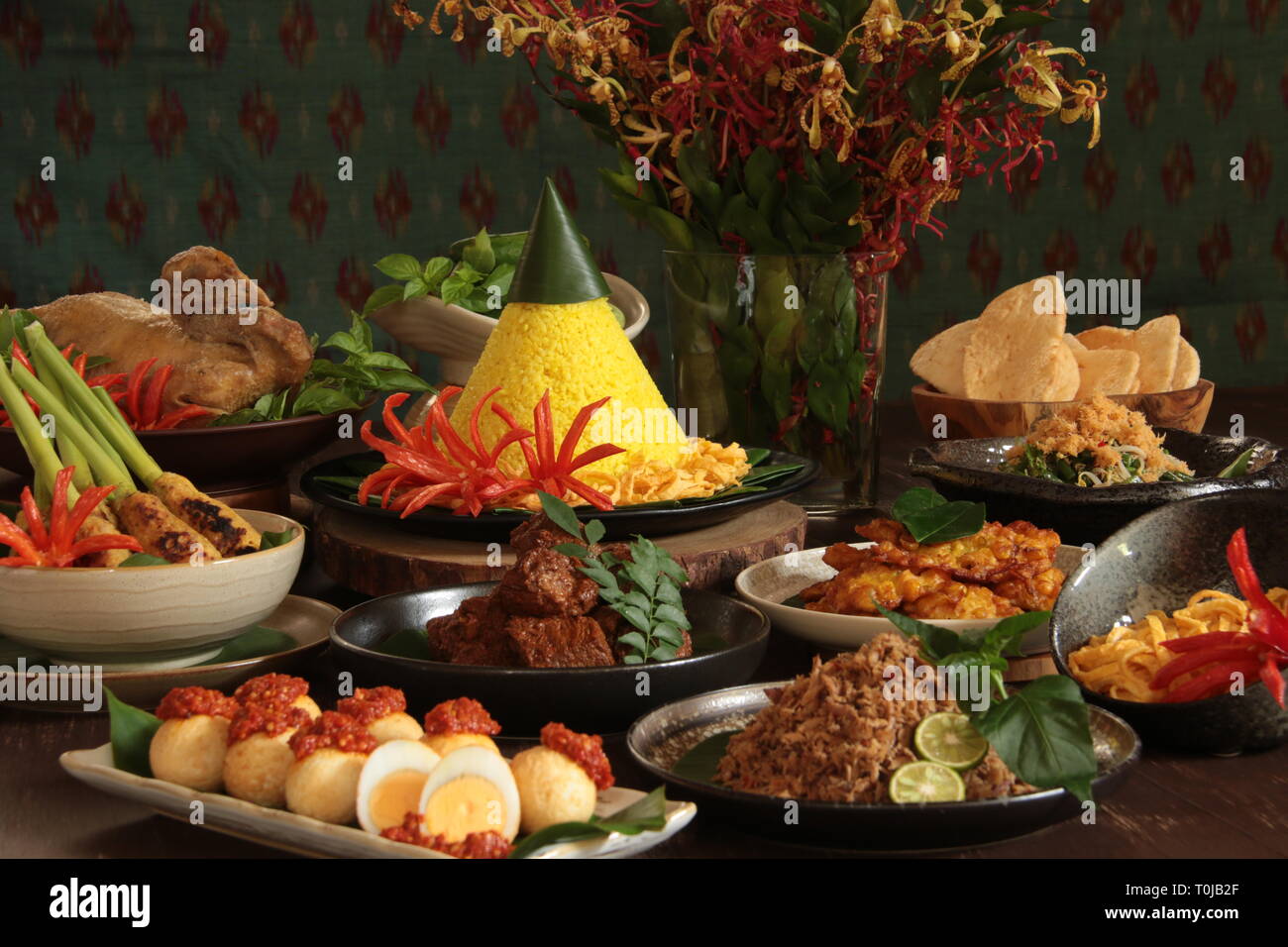 Nasi Tumpeng Nusantara. Festosa e grand Rijsttafel indonesiano di riso giallo a forma di cono con sette lati piatti dalla cucina regionale. Foto Stock