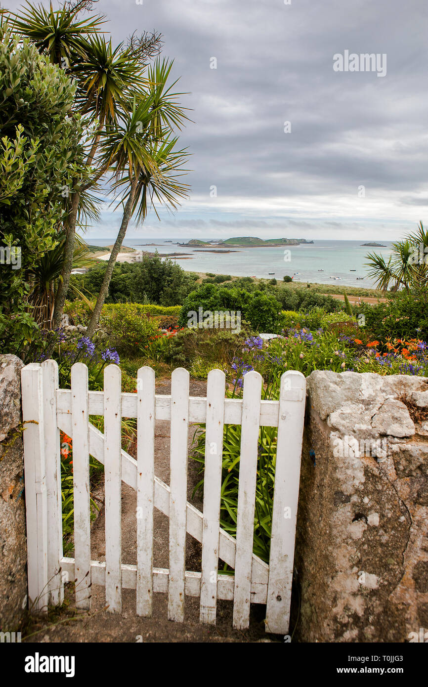 Garden gate e una vista della maggiore città della baia e le isole orientali da San Martin's, isole Scilly, REGNO UNITO Foto Stock