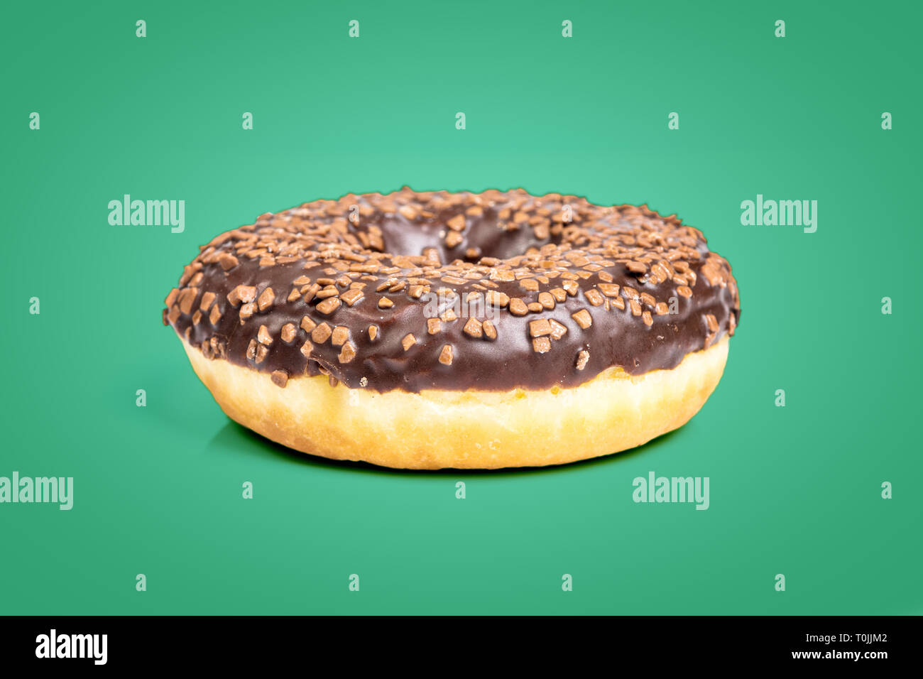 Dolce ciambella di cioccolato isolato su sfondo verde Foto Stock