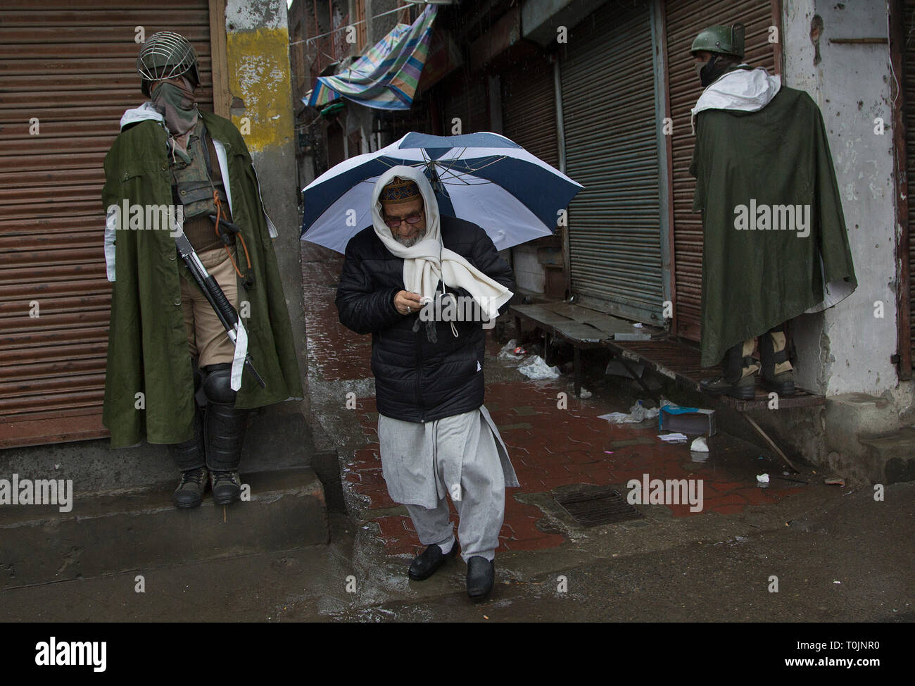 Srinagar Kashmir. 20 Mar, 2019. Un uomo cammina passato paramilitari indiano di soldati a un mercato chiuso durante il blocco di protezione a Srinagar, la capitale estiva ofKashmir, Marzo 20, 2019. La vita normale nella maggioranza musulmana aree dell'irrequieta India-Kashmir controllato il mercoledì sono rimasti colpiti a causa di uno sciopero sulla pena di morte di un insegnante della scuola. La chiamata per sciopero è stato dato dalla regione di gruppi separatisti sotto il vessillo della resistenza comune Leadership (JRL). Credito: Javed Dar/Xinhua/Alamy Live News Foto Stock