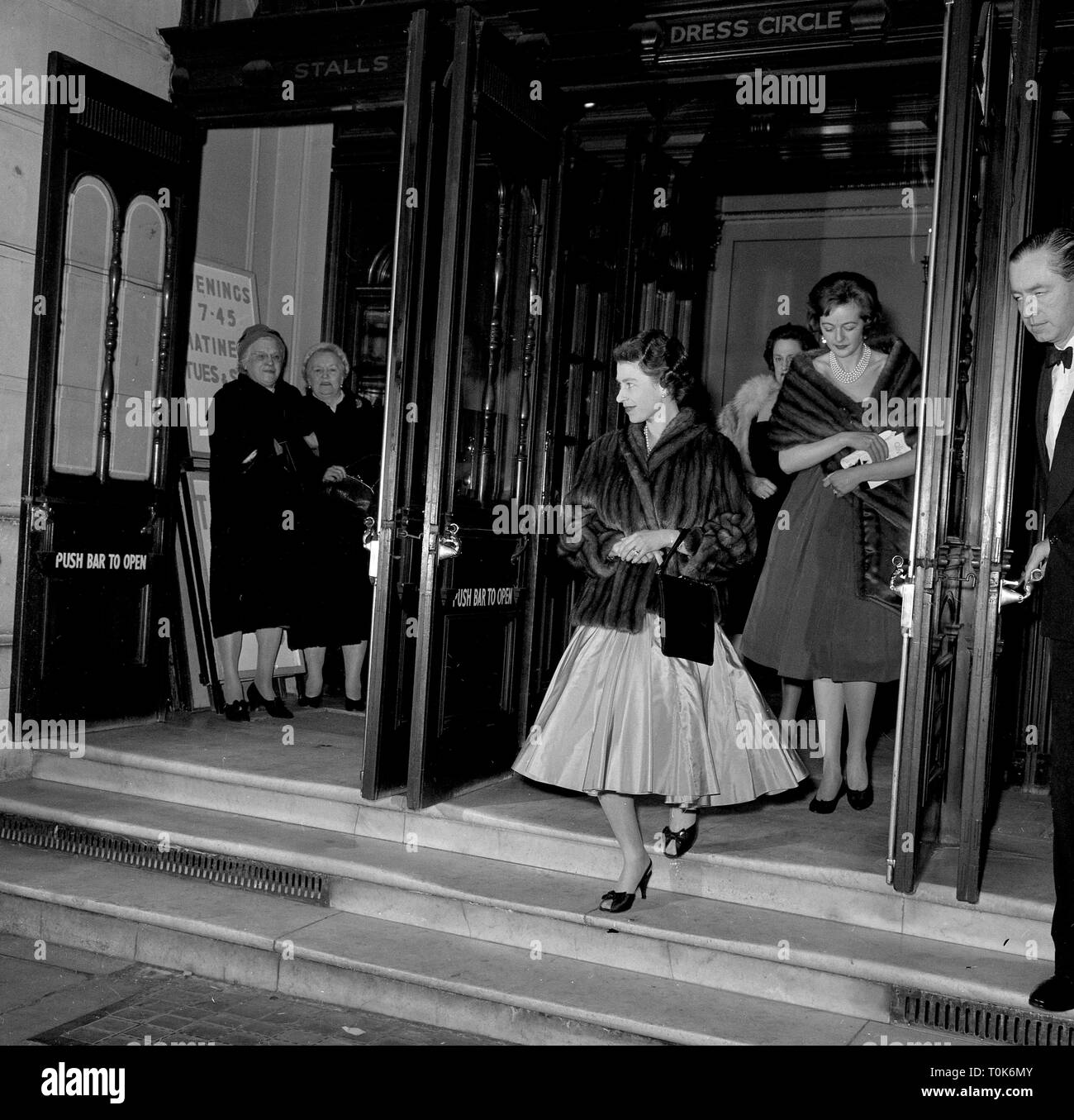 La regina Elisabetta II, che indossa un capo di pelliccia nel corso della sua breve cocktail abito da sera, lascia il Nuovo Teatro di Londra, dopo aver frequentato una performance di 'Oliver!". Foto Stock
