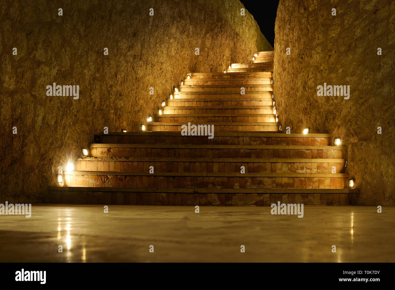 Bella scala di gradini con luce gialla di notte in un albergo su uno sfondo scuro. Foto Stock