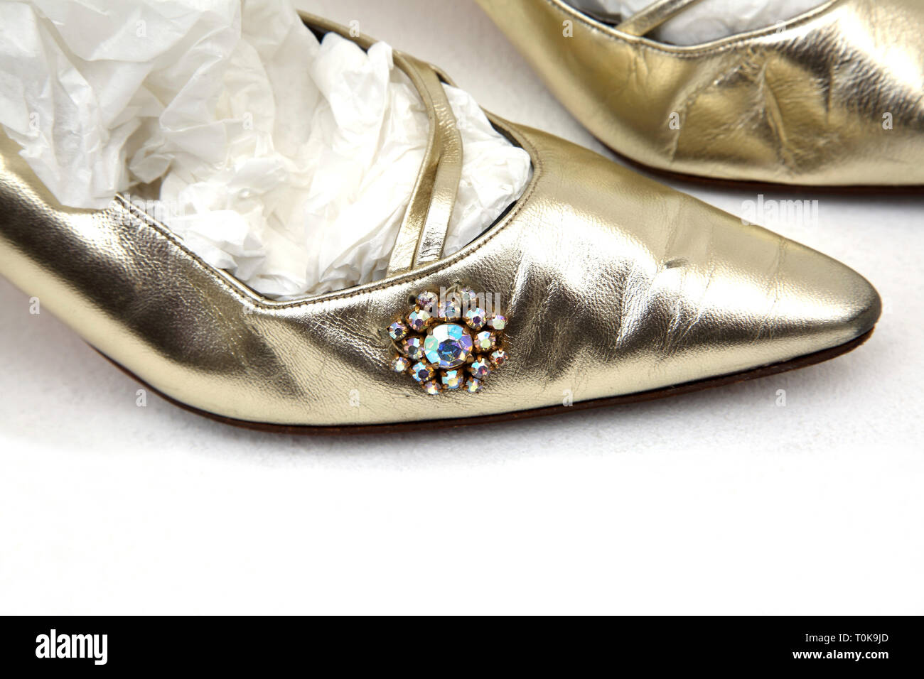 Una coppia di oro gattino scarpe tacco vicino sul gioiello sul lato Foto Stock
