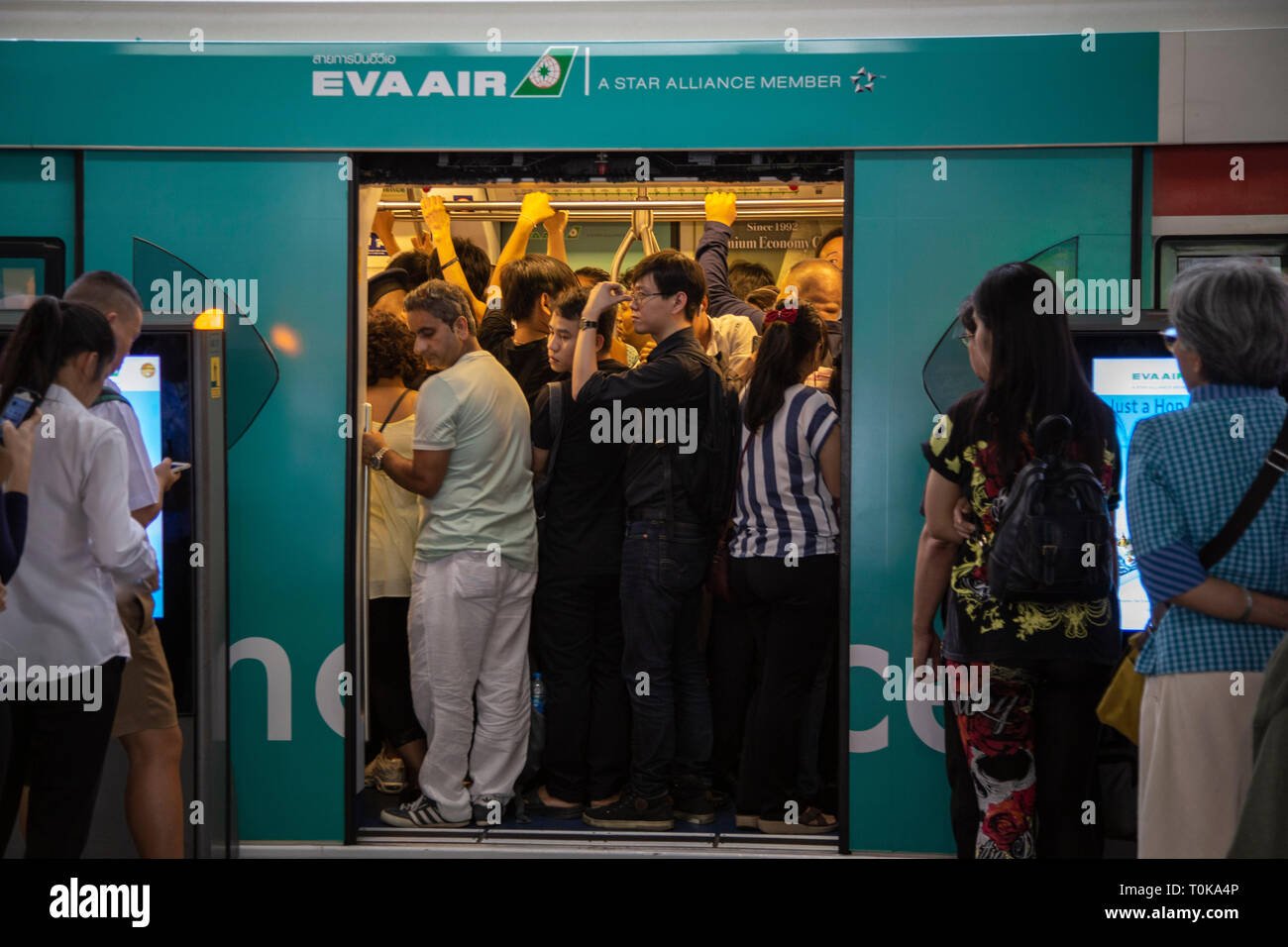 Le persone che entrano nel skytrain, treno di Bangkok, Tailandia in modo ordinato ma molto spinti modo Foto Stock
