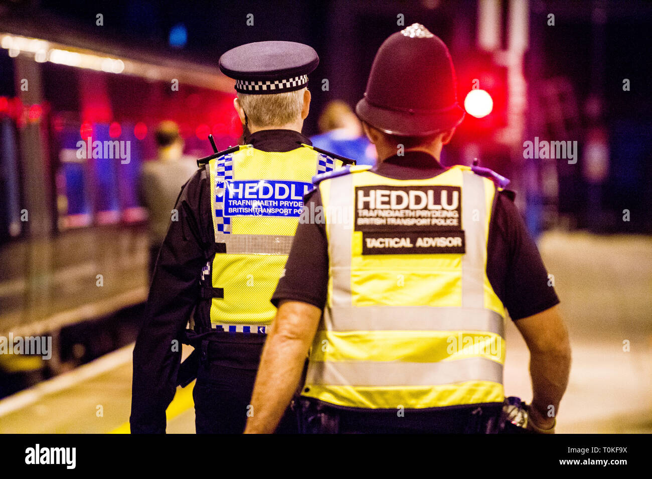 British Transport Police in uniforme a piedi lungo il lato di un treno Foto Stock