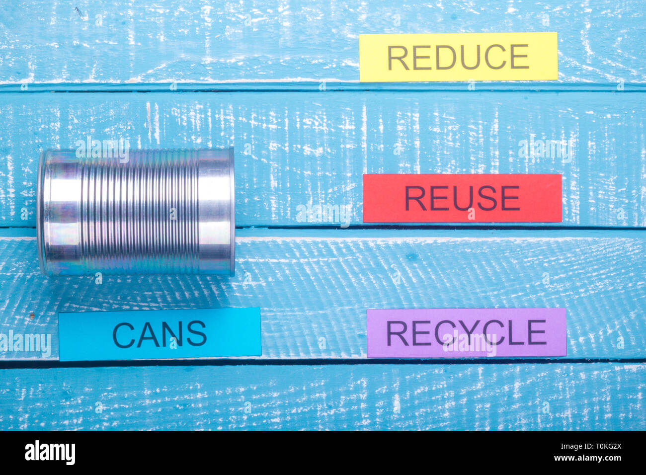 Concetto di riciclo che mostra ridurre, riutilizzare e riciclare con le lattine su un blu sfondo spiovente Foto Stock