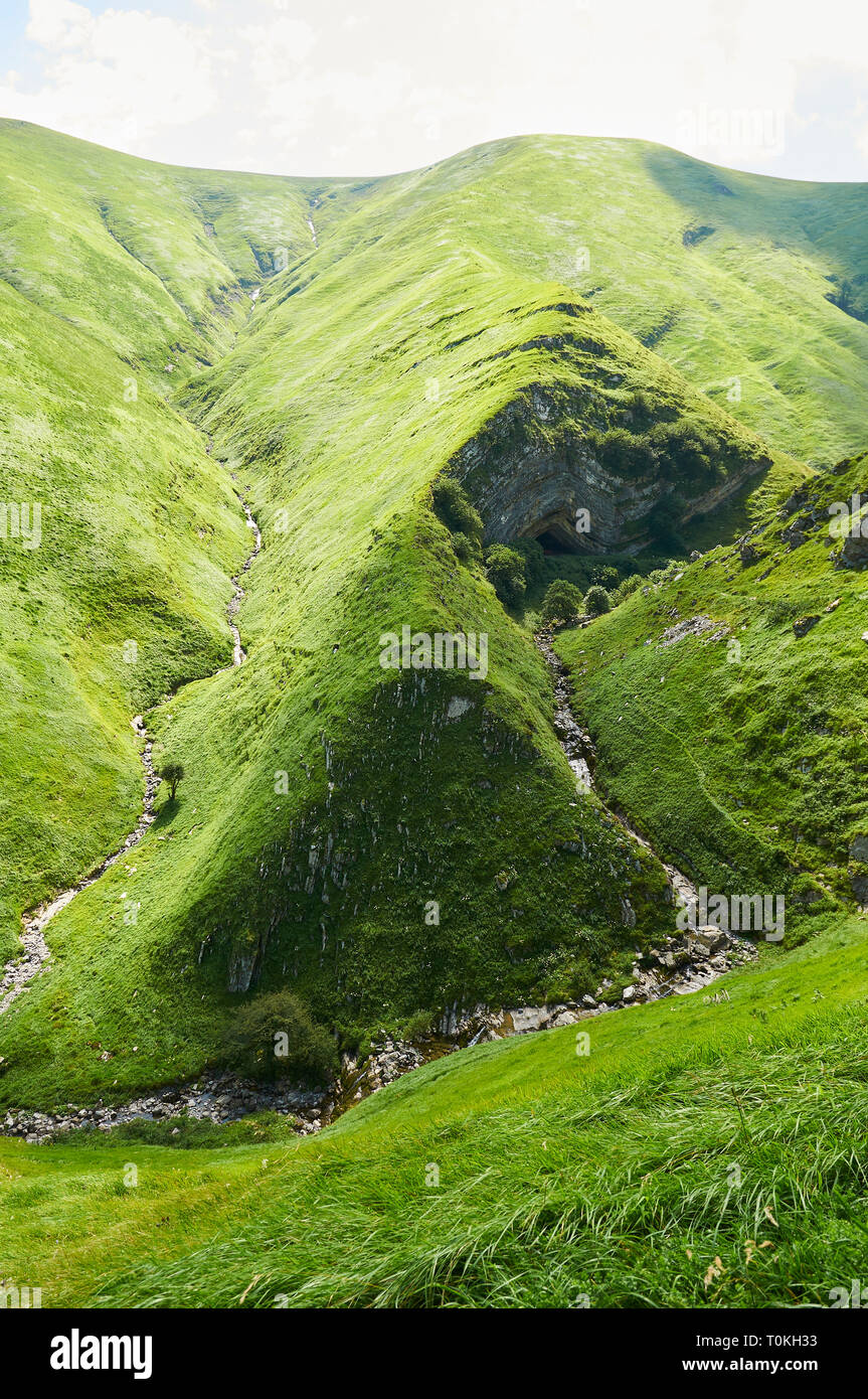 Verdi colline e Harpéko Erréka creek vicino Arpea grotta, spettacolare piega anticlinale piega circondato da verdi pascoli nei Pirenei francesi (Estérençuby,Francia) Foto Stock
