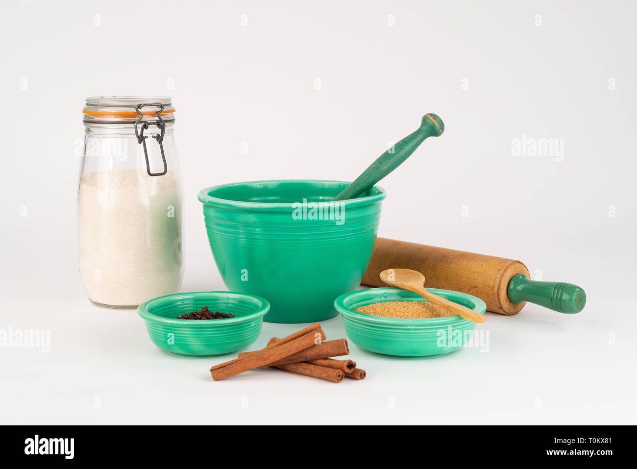 La cottura Ingredienti con Vintage Fiesta Ware bocce e antichi mattarello. La cannella, zucchero organico, farina di grano in un barattolo di vetro. Il cucchiaio di legno. Foto Stock