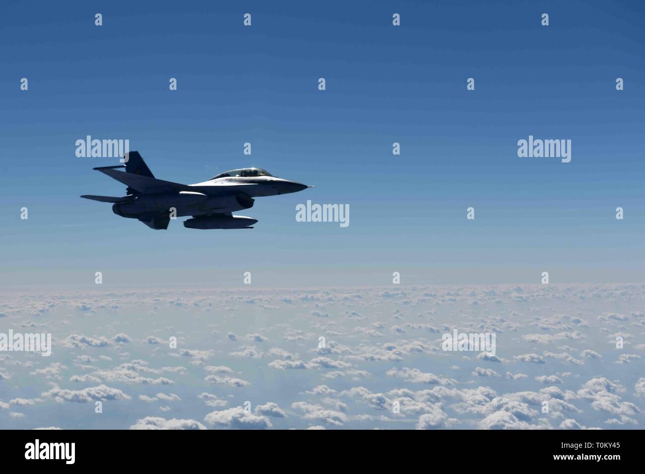 Un rumeno air force F-16 vola accanto ad un centesimo Air Refuelling Wing KC-135 Stratotanker da RAF Mildenhall, Inghilterra prima di ricevere il carburante durante il rifornimento di carburante antenna formazione oltre i cieli di Romania, 13 marzo 2019. La formazione è stata un esempio di Stati Uniti e alleati della NATO la condivisione di un impegno per promuovere la pace e la stabilità attraverso lo sviluppo della loro relazione e il processo di comunicazione. (U.S. Air Force foto di Airman 1. Classe Brandon Esaù) Foto Stock