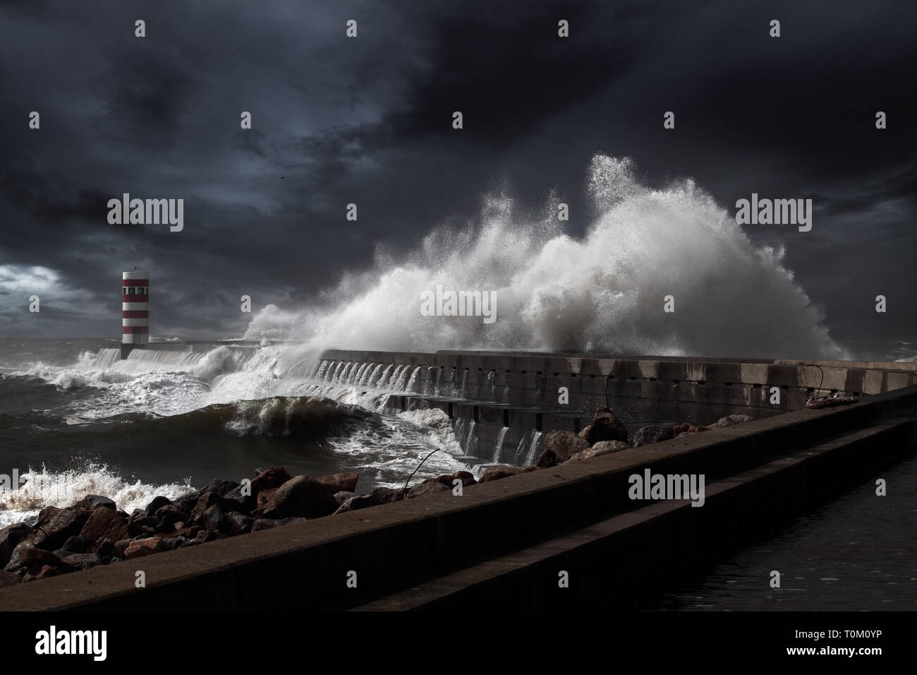 Faro e pier sotto pesante tempesta. Enhanced sky. Foto Stock
