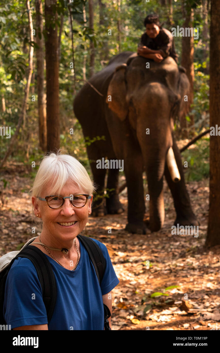 Cambogia, zone di Mondulkiri Provincia, Sen Monorom, Valle di elefante progetto turistico senior che posano per una fotografia con Hen, maschio ex logging elephant walki Foto Stock