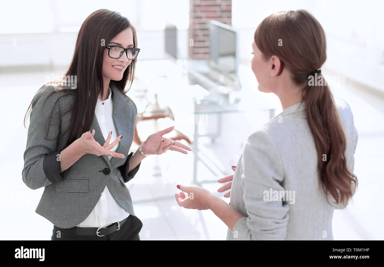 Due dipendenti discutono in piedi in ufficio Foto Stock