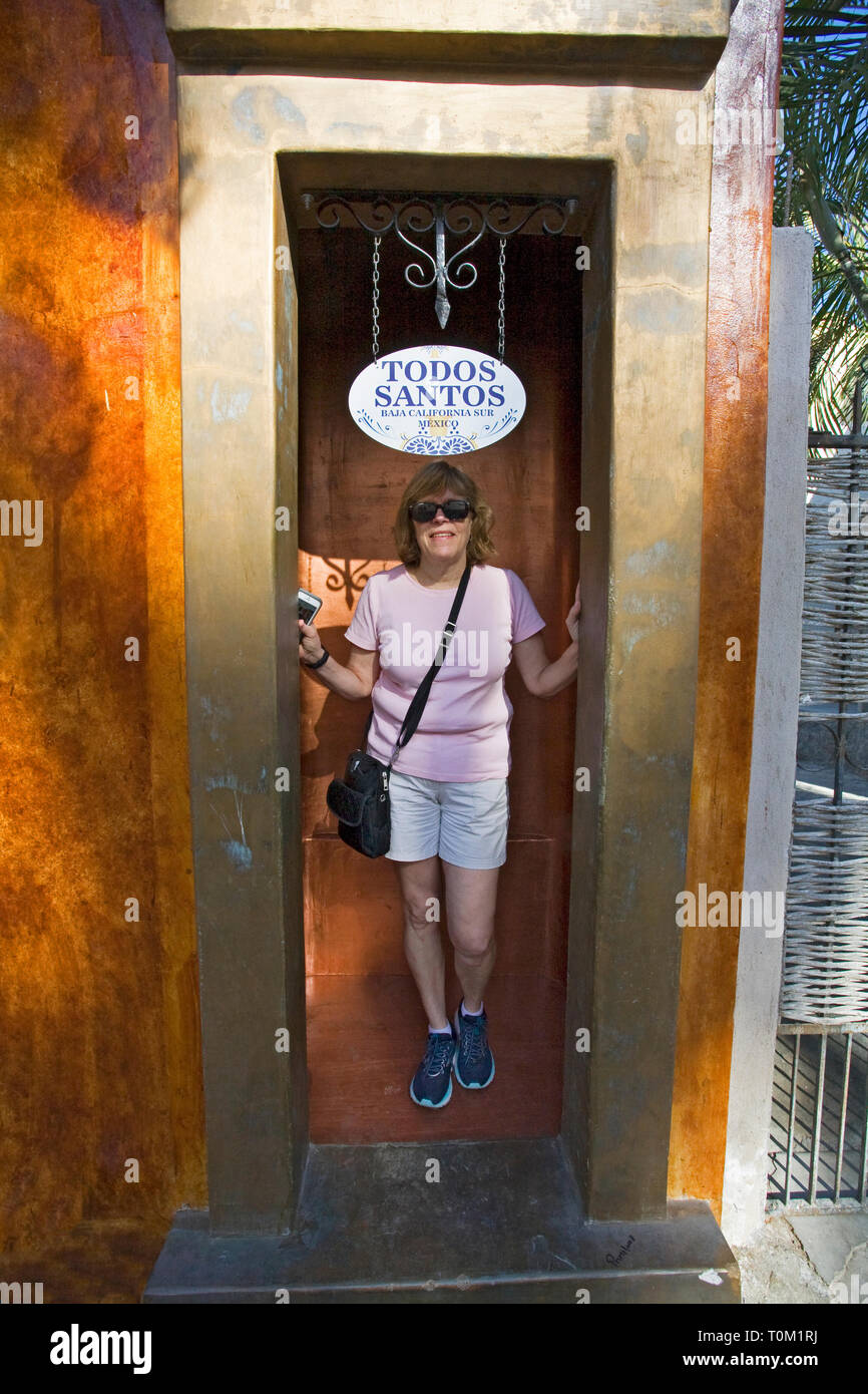 Un turista americano mette in pausa il vano di una porta su una strada laterale nella cittadina turistica di Todos, Santos, Baja, Messico. Foto Stock