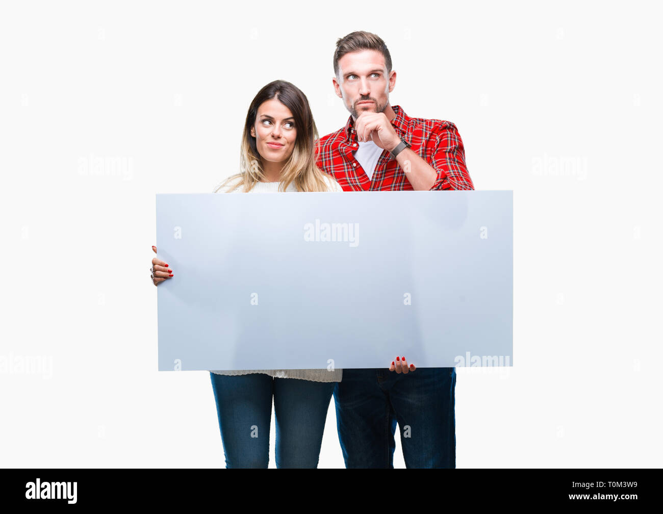 Coppia giovane insieme azienda banner bianco su sfondo isolato faccia seriamente pensando di domanda, molto confusa idea Foto Stock