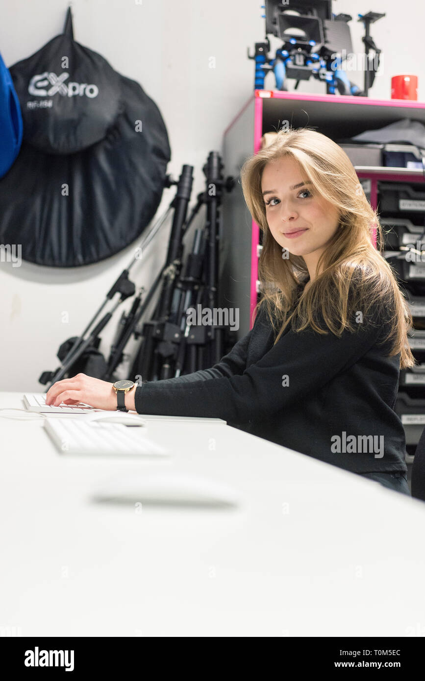 Una femmina di media studente in aula di Brighton College con il computer, le fotocamere digitali e l'illuminazione da un corso di film Foto Stock