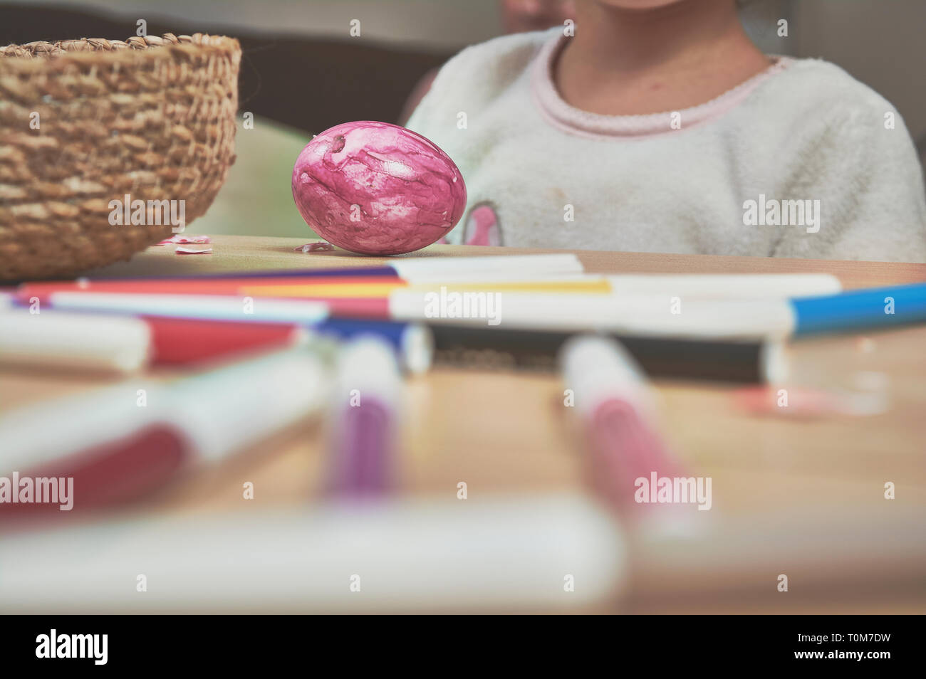 I bambini di pittura delle uova di Pasqua con la loro mamma e aiutare con i marcatori a casa Foto Stock