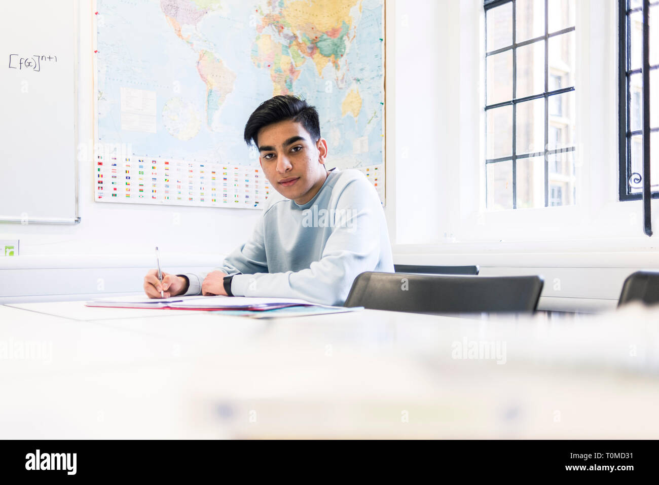 Uno studente internazionale studi hard in una classe in un College di Cambridge Foto Stock