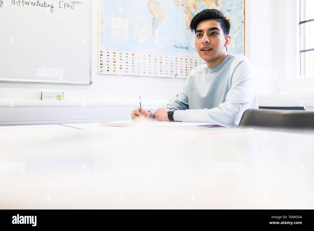 Uno studente internazionale studi hard in una classe in un College di Cambridge Foto Stock