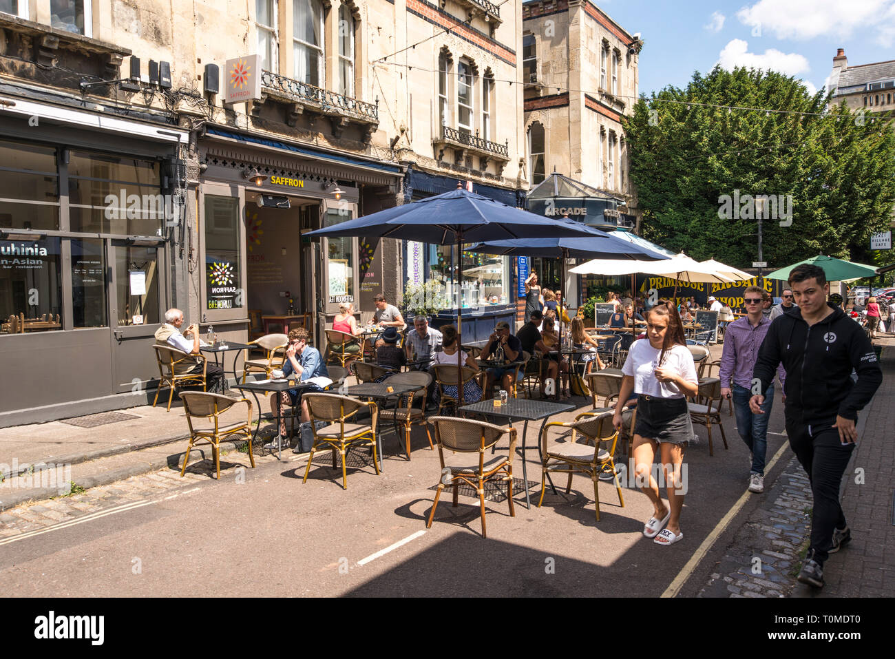La gente seduta al di fuori di godersi le giornate di sole e caffè, Boyces Ave, Bristol, Regno Unito Foto Stock