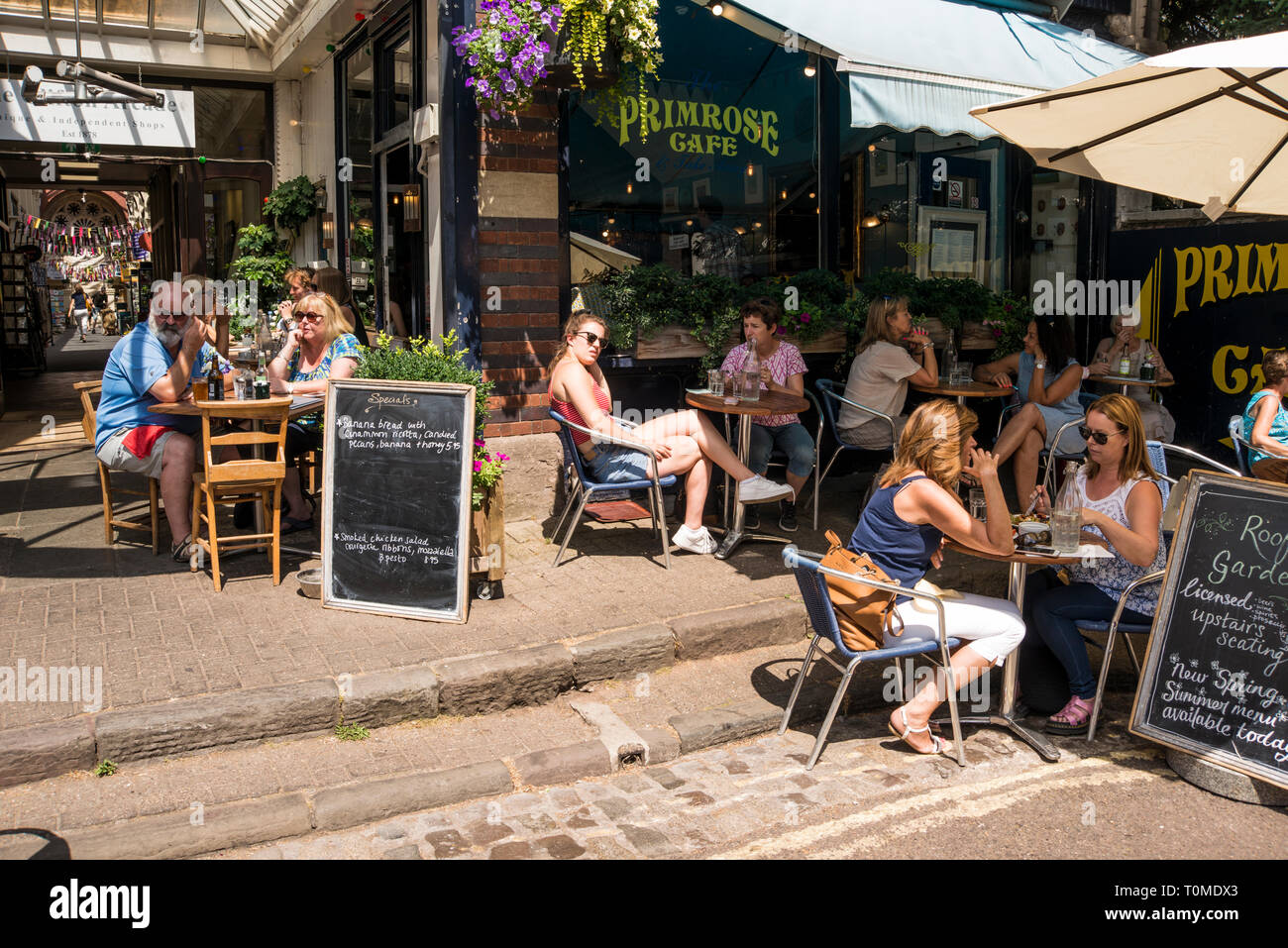 La gente seduta al di fuori di godersi le giornate di sole e caffè, Boyces Ave, Bristol, Regno Unito Foto Stock