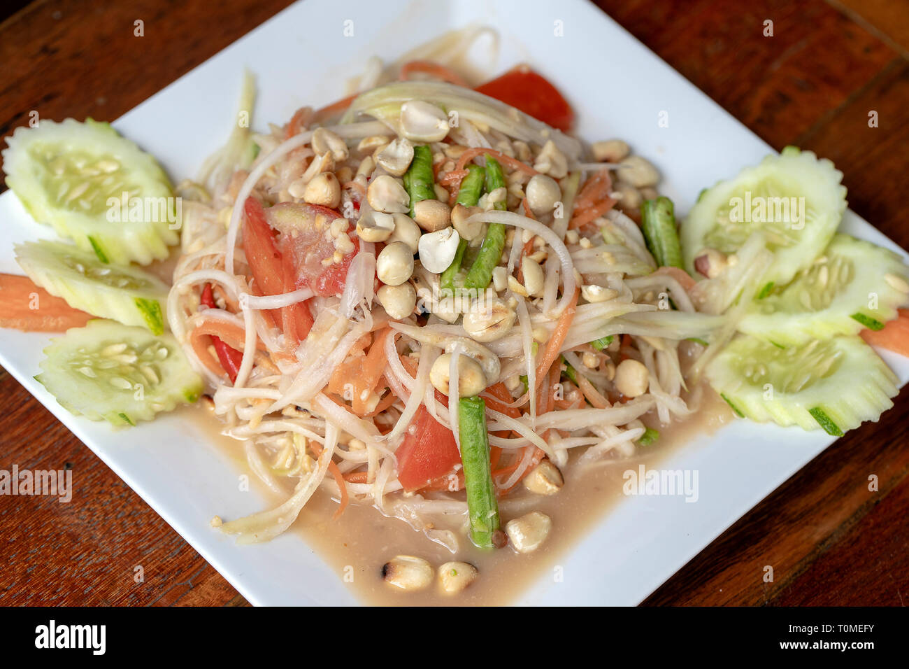 La papaia verde insalata o Som tum Thai in piastra bianca, vicino. Cucina thailandese, somtum insalata di cibi popolari in Thailandia Foto Stock