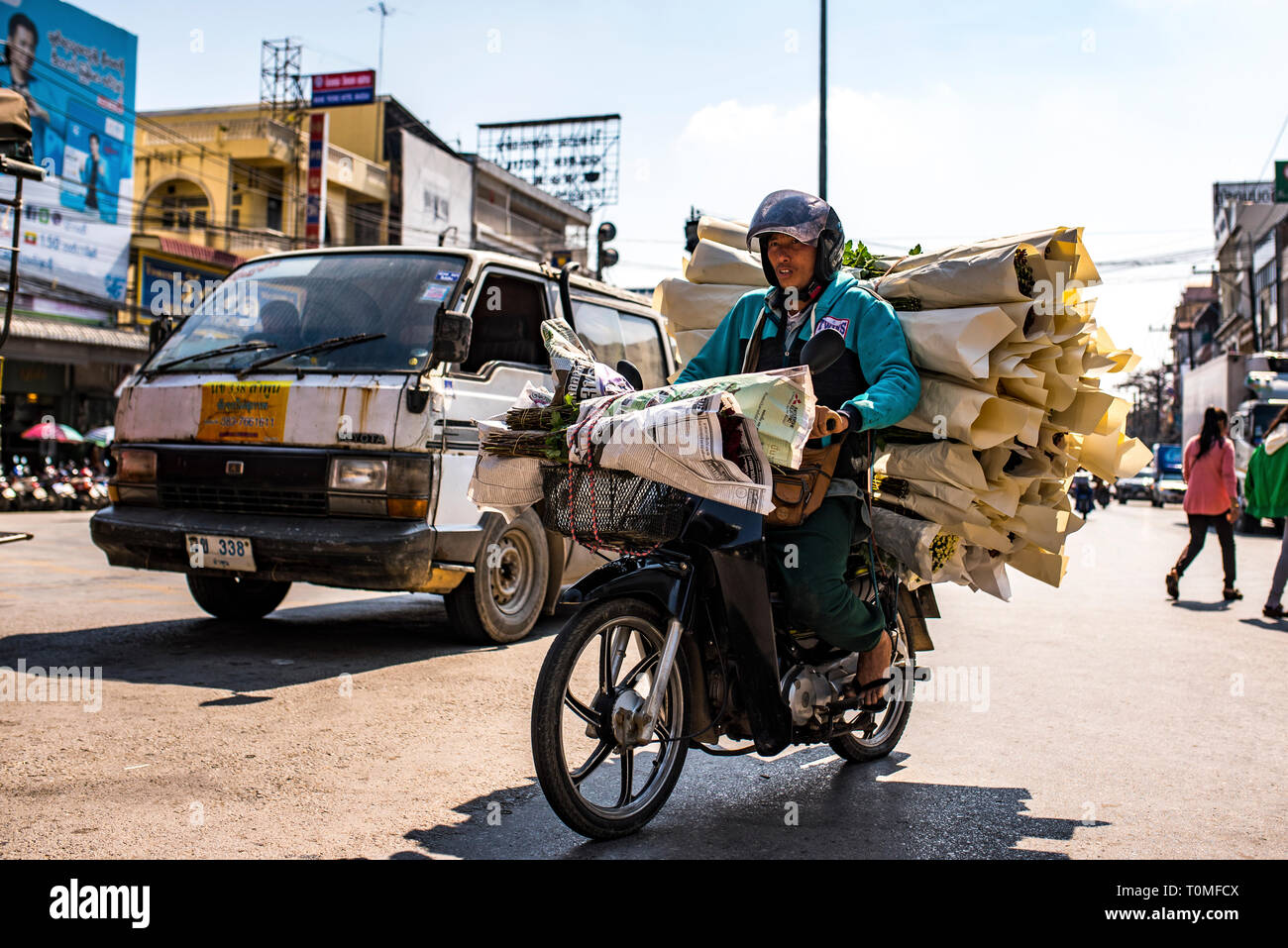 Motociclista trasporta i fiori, frontiera a Myanmar, Laos Foto Stock
