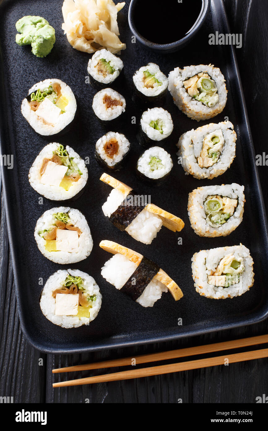 Rulli giapponese, Hosomaki Uramaki, maki e nigiri, Tamagoyaki con vari ripieni di close-up su una piastra sul tavolo. Verticale in alto vista da sopra Foto Stock