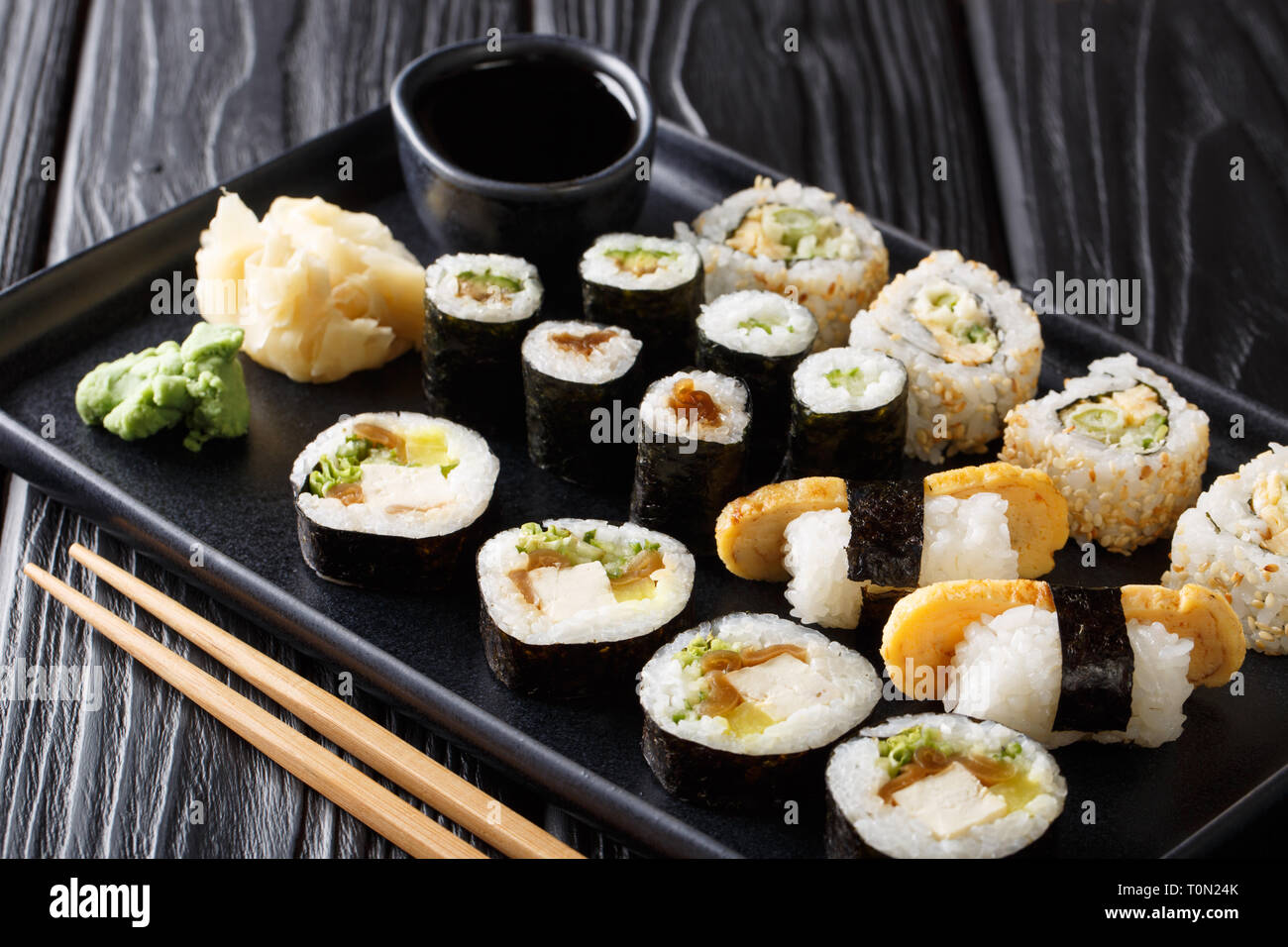 Delizioso sushi giapponese rotoli set di grandi dimensioni con frutti di mare, verdure, tofu e tamago closeup su una piastra sul tavolo orizzontale. Foto Stock