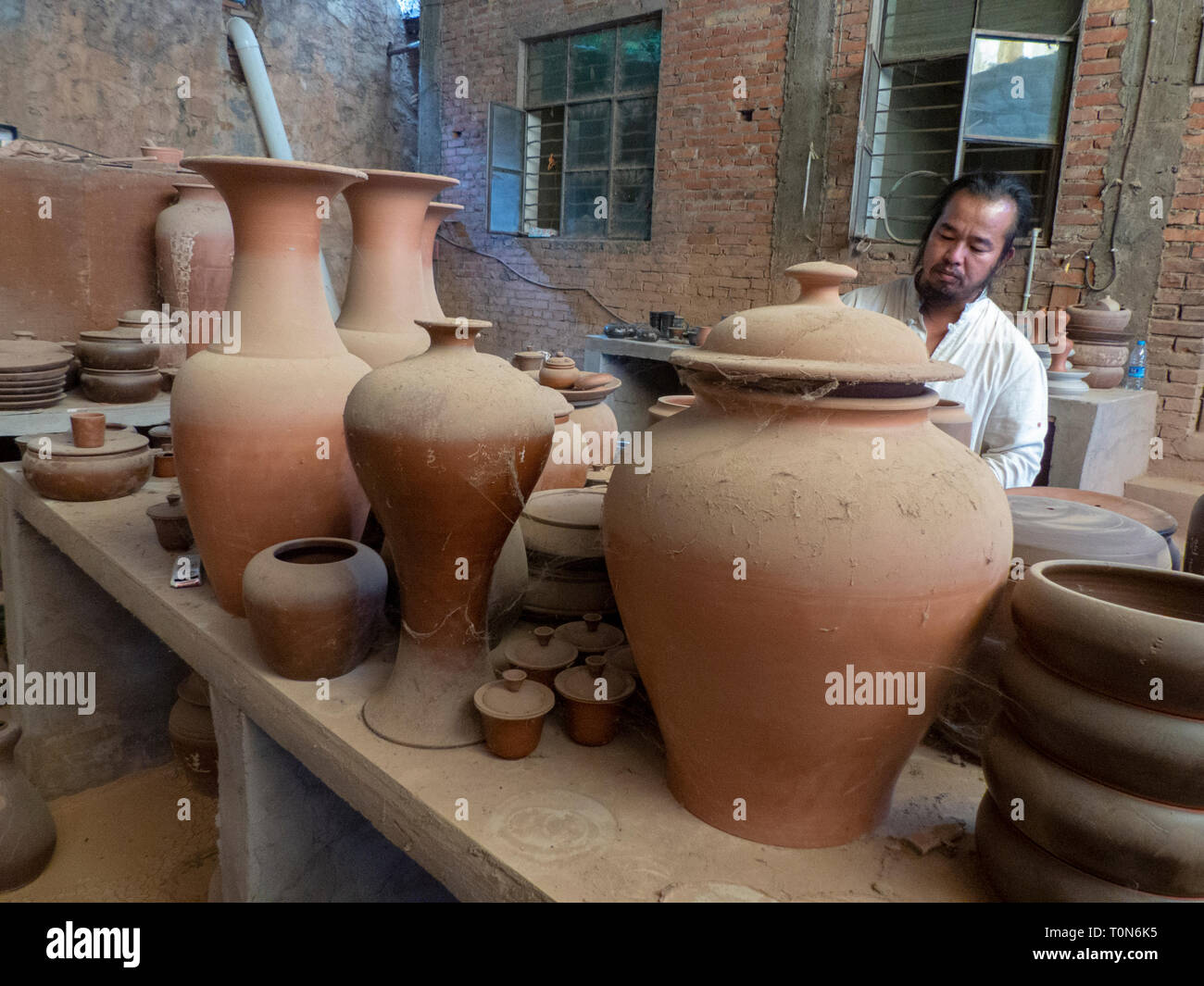 Potter nel suo workshop getta un vaso sul tornio del vasaio in Jianshui, Honghe prefettura, nella provincia dello Yunnan in Cina. Foto Stock