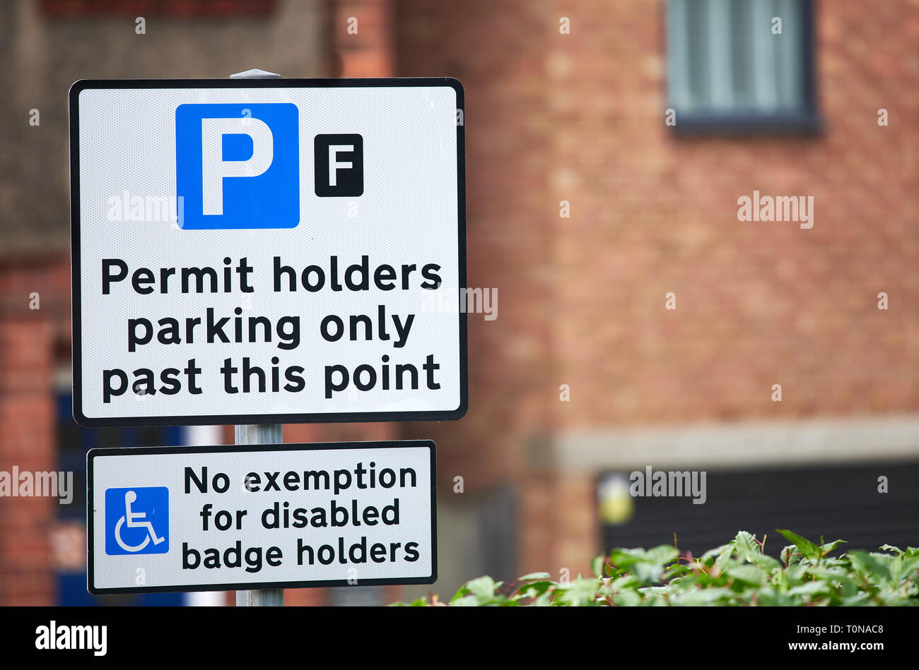 Gli avvisi che mostra i posti di parcheggio per i titolari di autorizzazioni solo con nessuna esenzione per disabili titolari di badge Foto Stock