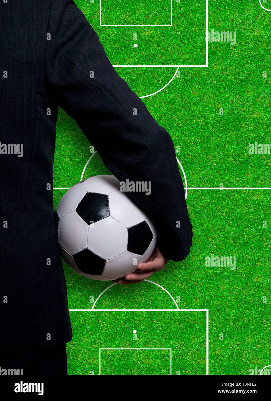 Uomo in tuta in possesso di un pallone da calcio, il calcio come concetto aziendale Foto Stock