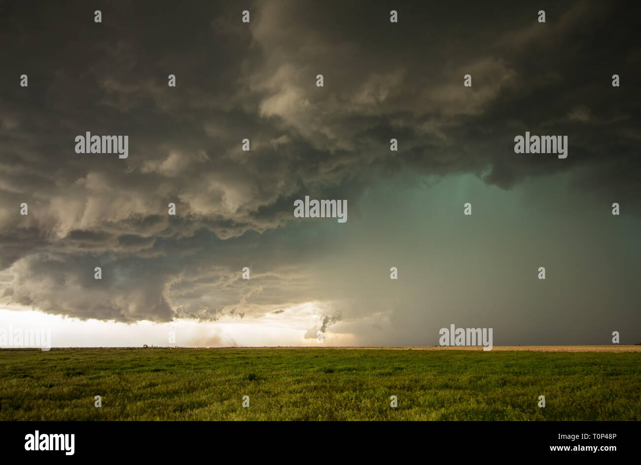 Un pericoloso supercell contenente tempesta di pioggia torrenziale e grandi grandine emette un bagliore verde nel cielo. Foto Stock