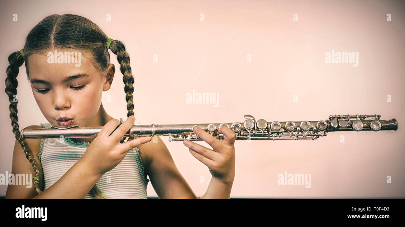 Schoolgirl riproduzione di flauto in aula Foto Stock