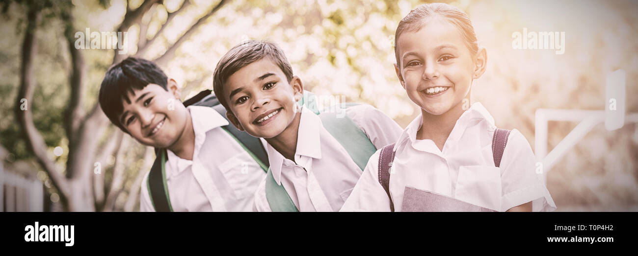 Ritratto di sorridere a scuola i bambini in piedi nel campus Foto Stock