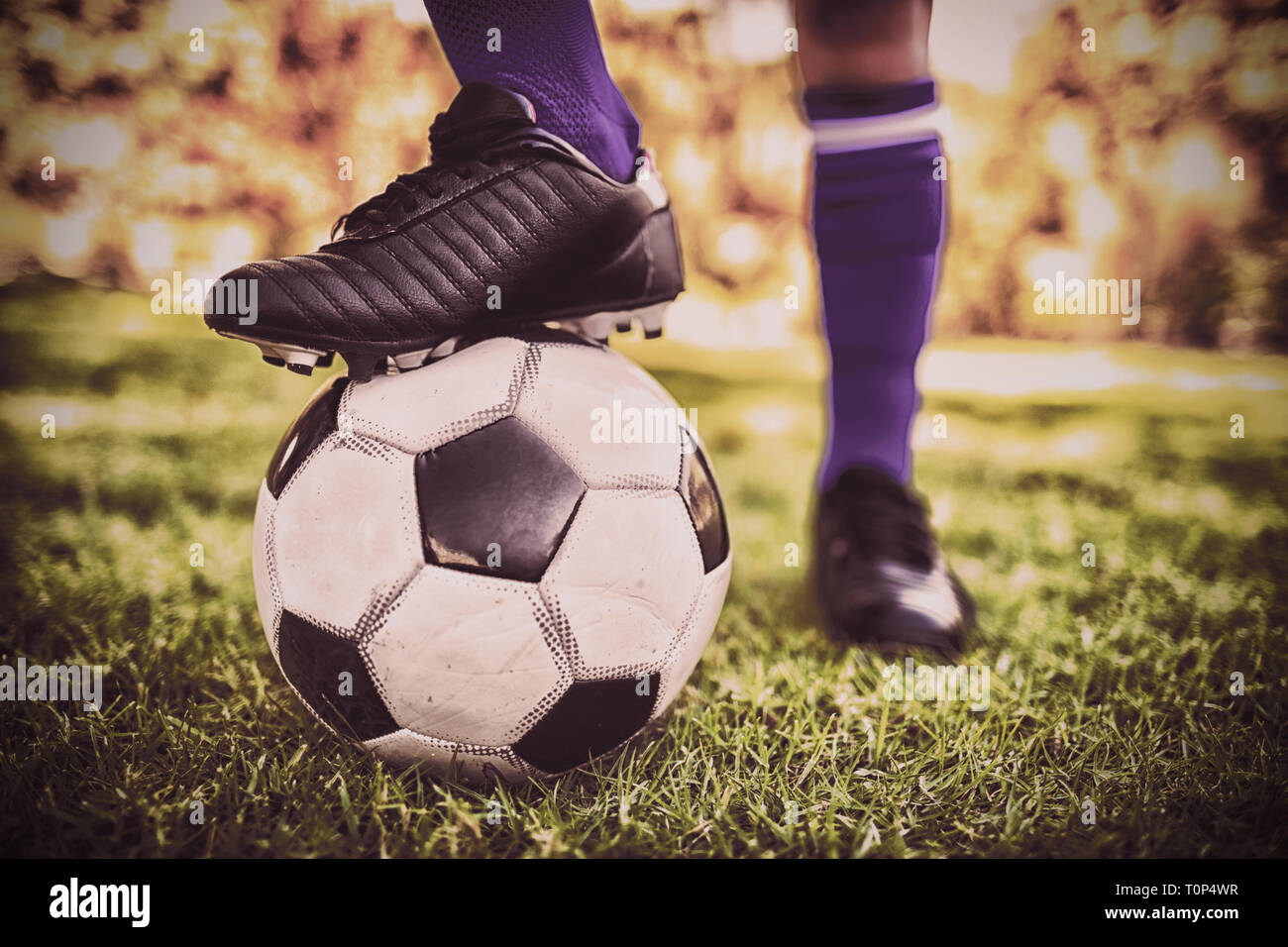 Vista ravvicinata del palloncino sotto gli scarpini da calcio in posizione di parcheggio Foto Stock