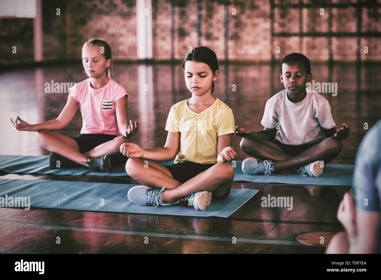 La scuola di meditazione per bambini durante la lezione di yoga Foto Stock