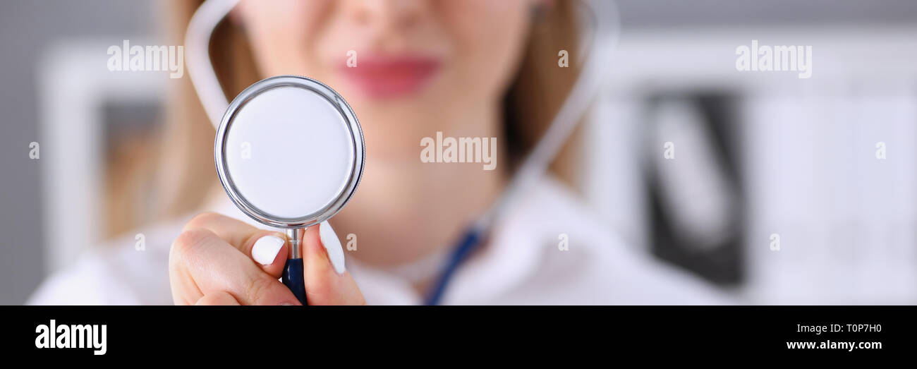 Bella donna sorridente medico tenere in mano la testa dello stetoscopio Foto Stock