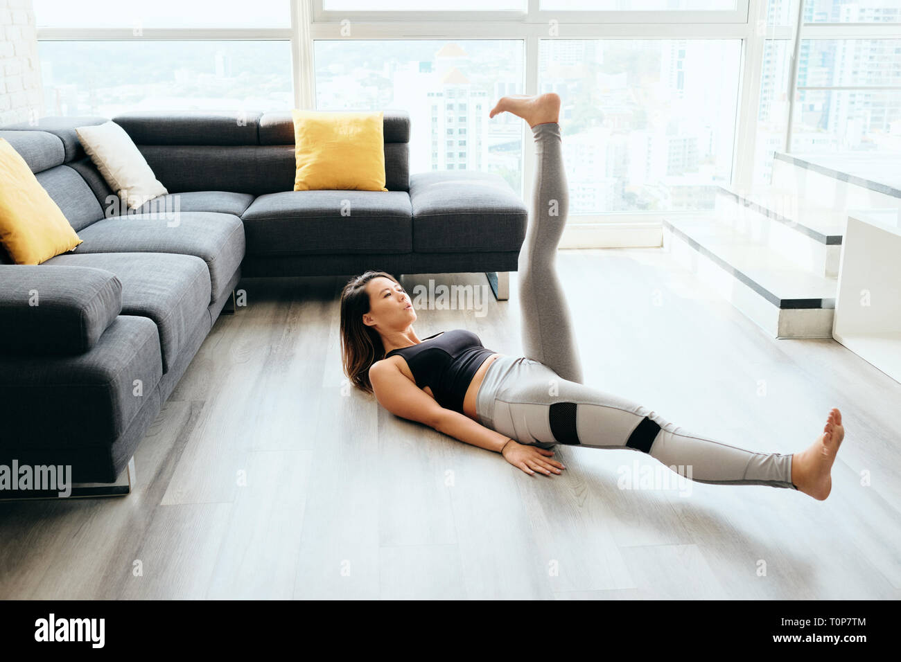 Donna adulta ABS Training addominali facendo forbici con le gambe Foto  stock - Alamy