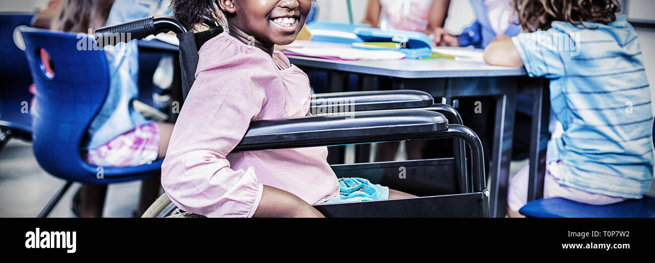 Disabilitato schoolgirl sorridente in aula Foto Stock