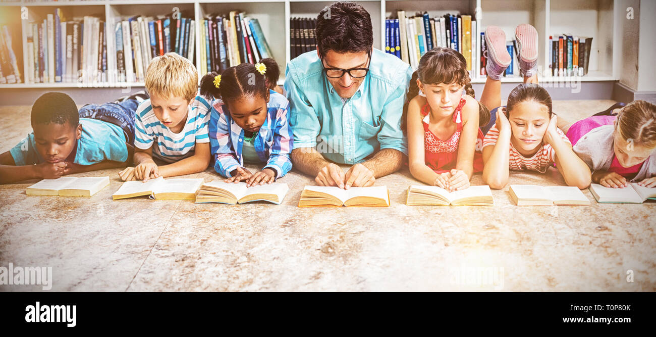 Insegnanti e bambini libro di lettura in biblioteca Foto Stock