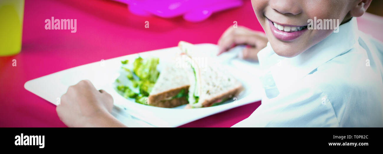 I bambini a pranzo durante la pausa nella caffetteria Foto Stock