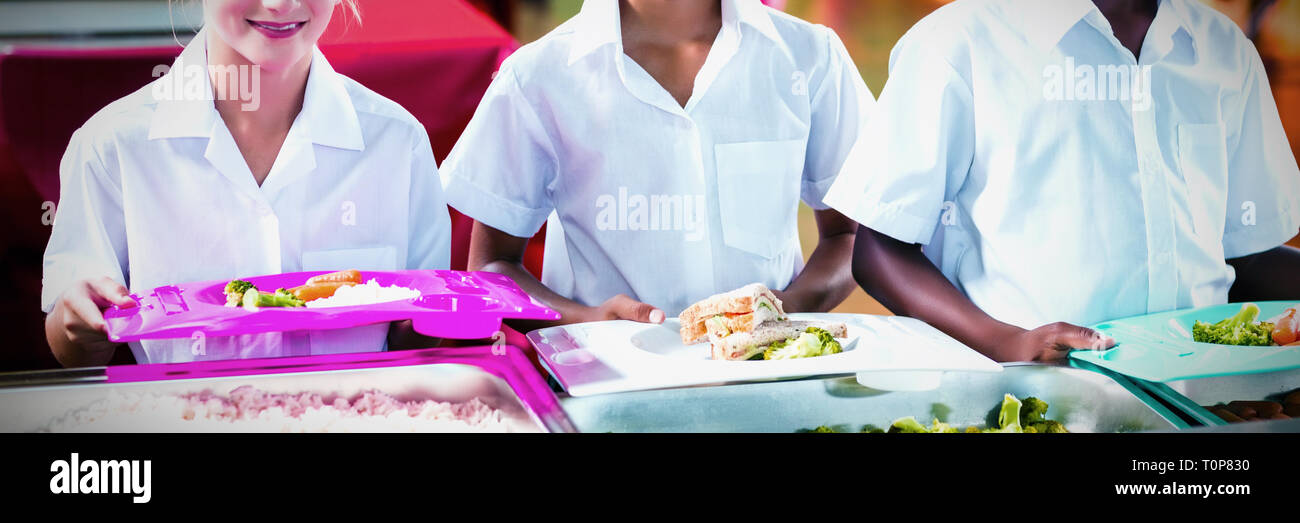 Ritratto di ragazzi in età scolare avente il pranzo durante il tempo di interruzione Foto Stock