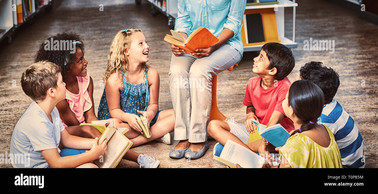 Insegnante con gli studenti la lettura di libri Foto Stock