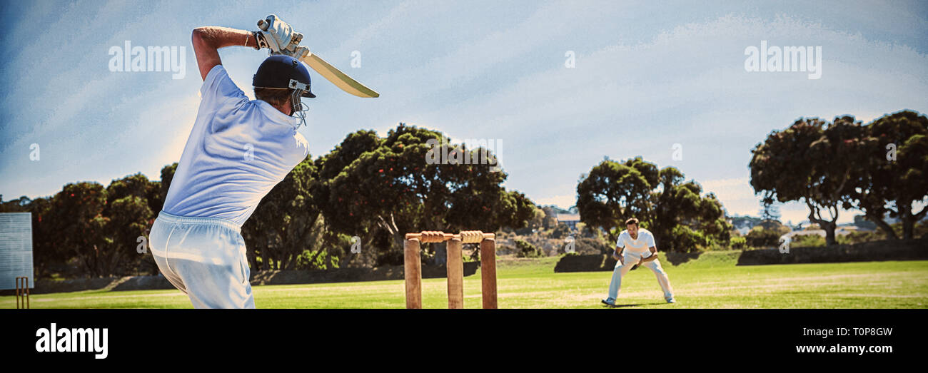 Player batting durante la riproduzione di cricket sul campo Foto Stock