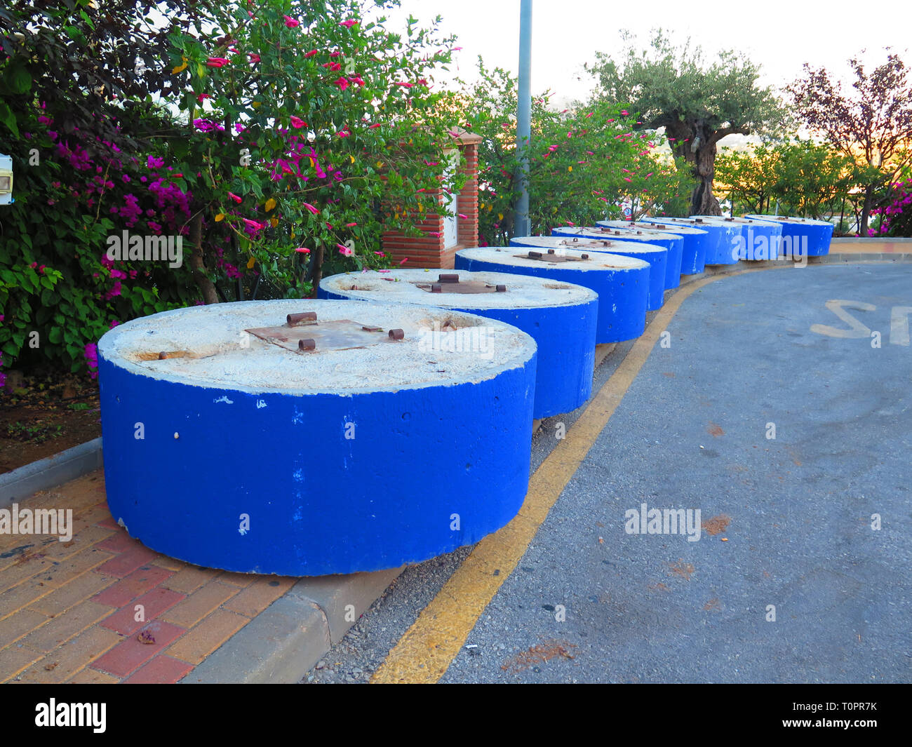 Circolare verniciato blu basi di calcestruzzo pronto per l'erezione di sun coperchio in villaggio andaluso, Spagna Foto Stock